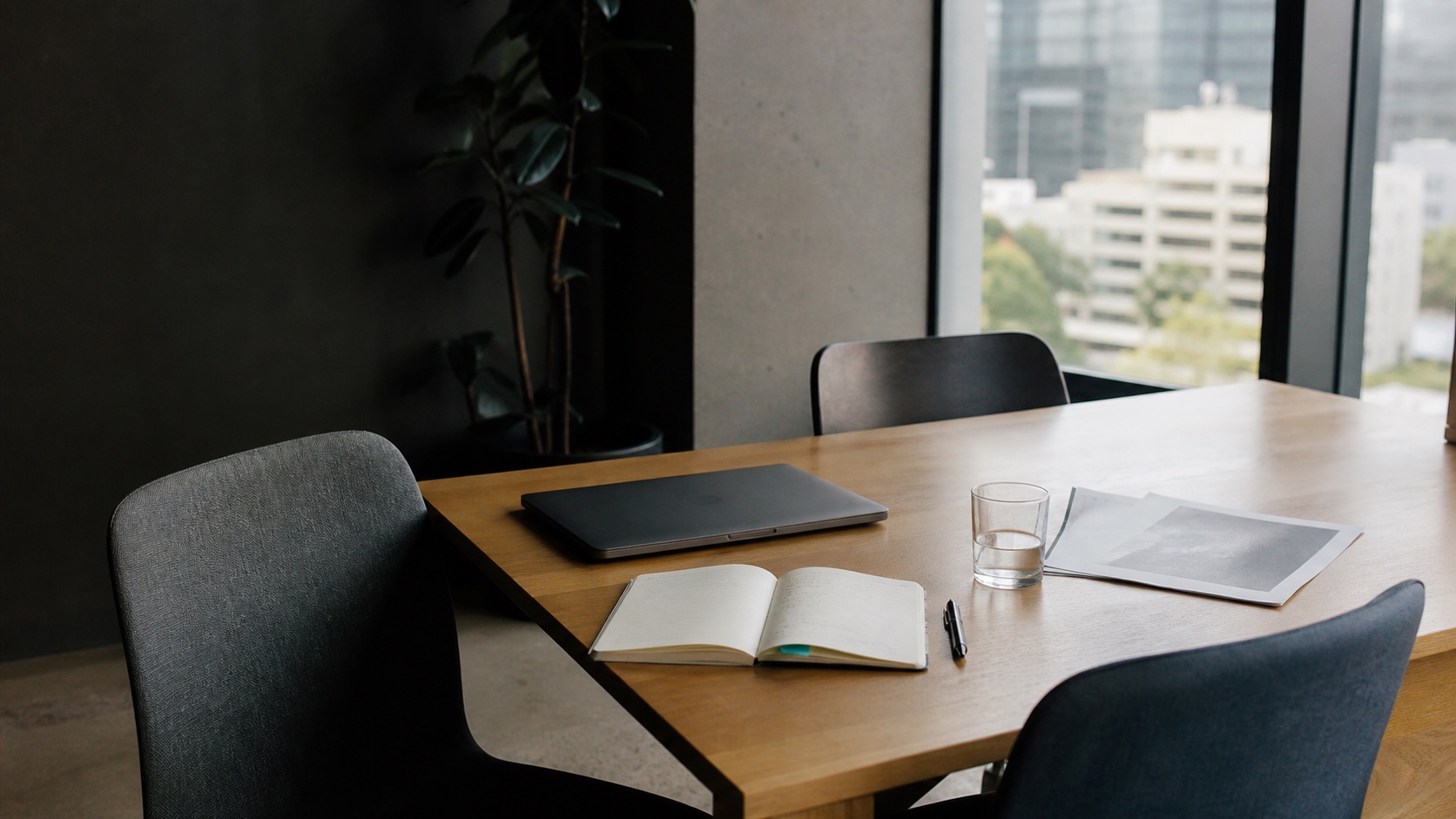 Professional services meeting table with a report, notebook and laptop in a Melbourne office